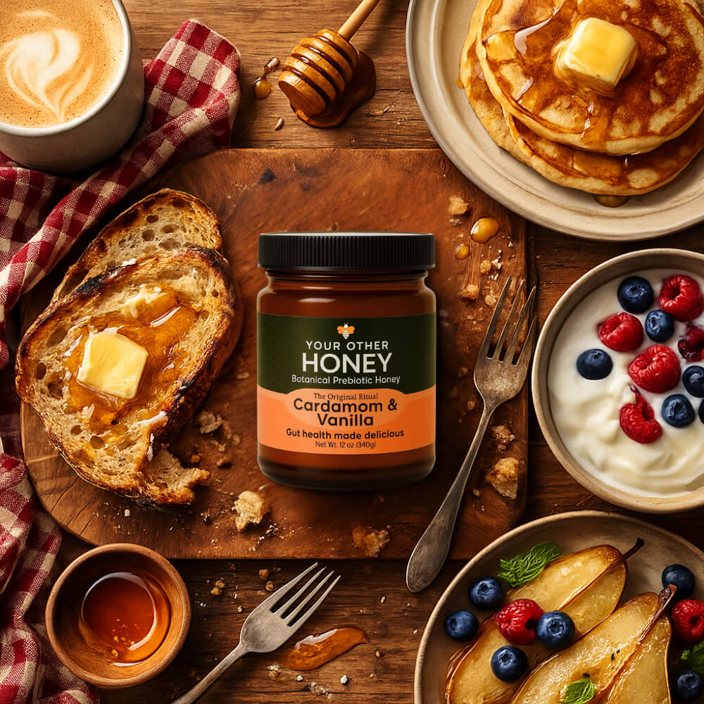 Your Other Honey jar on a wooden table with pancakes, toast, and fruit.