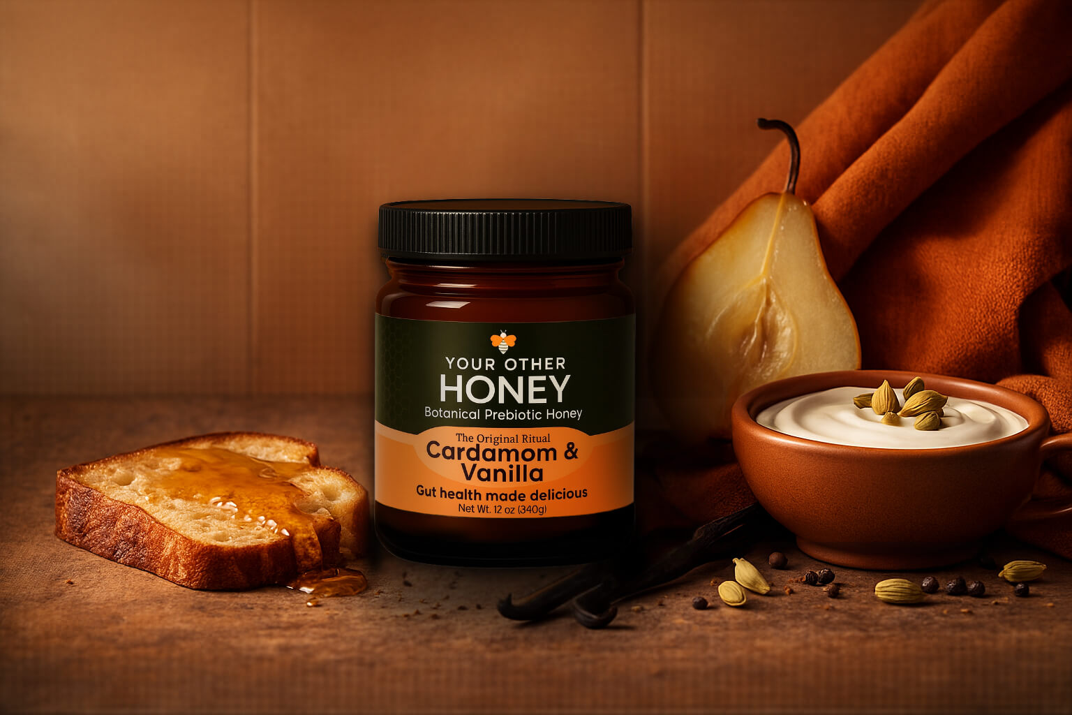Jar of 'Your Other Honey' cardamom honey on a wooden surface with bread, pear, and bowl.