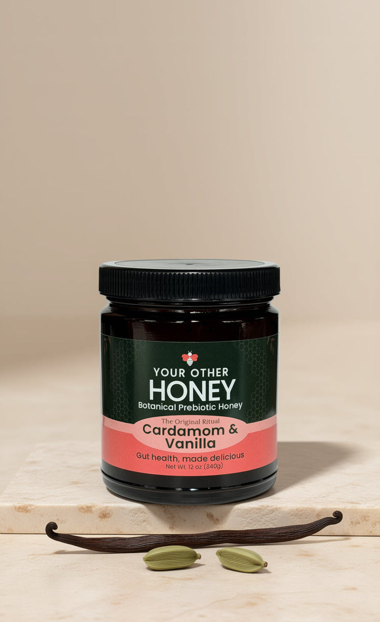 Jar of 'Your Other Honey' Cardamom & Vanilla honey on a beige background with vanilla beans and cardamom seeds.